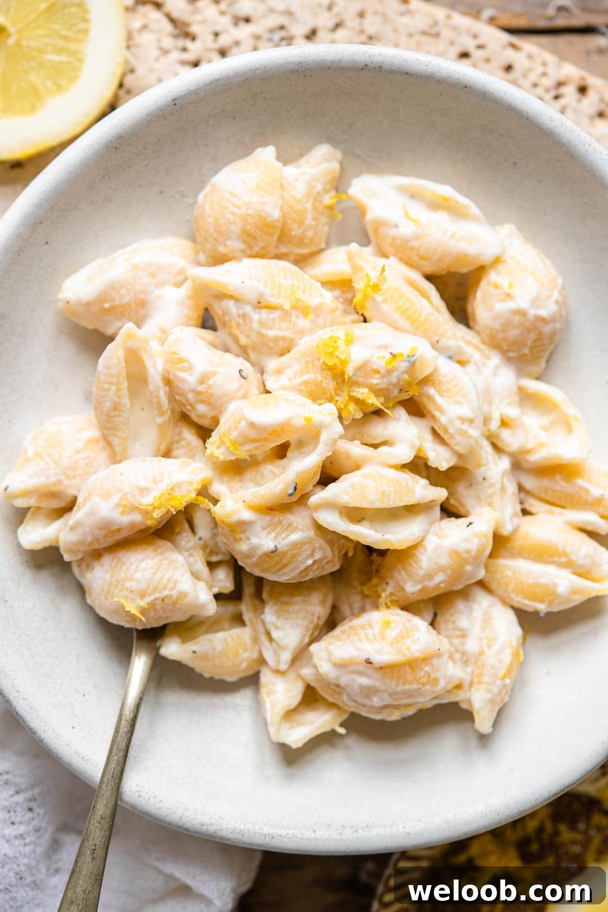 An overhead shot of ricotta lemon pasta in a bowl with fresh lemon zest
