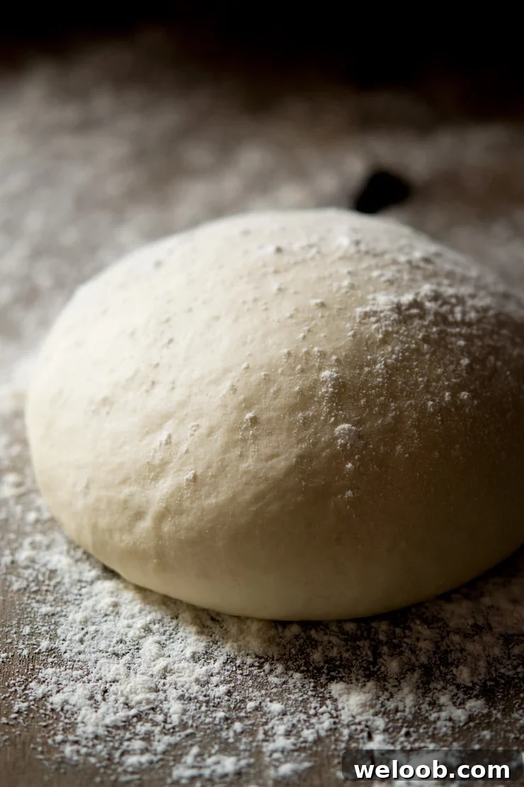 A close up of the best basic pizza dough sitting on a wooden surface