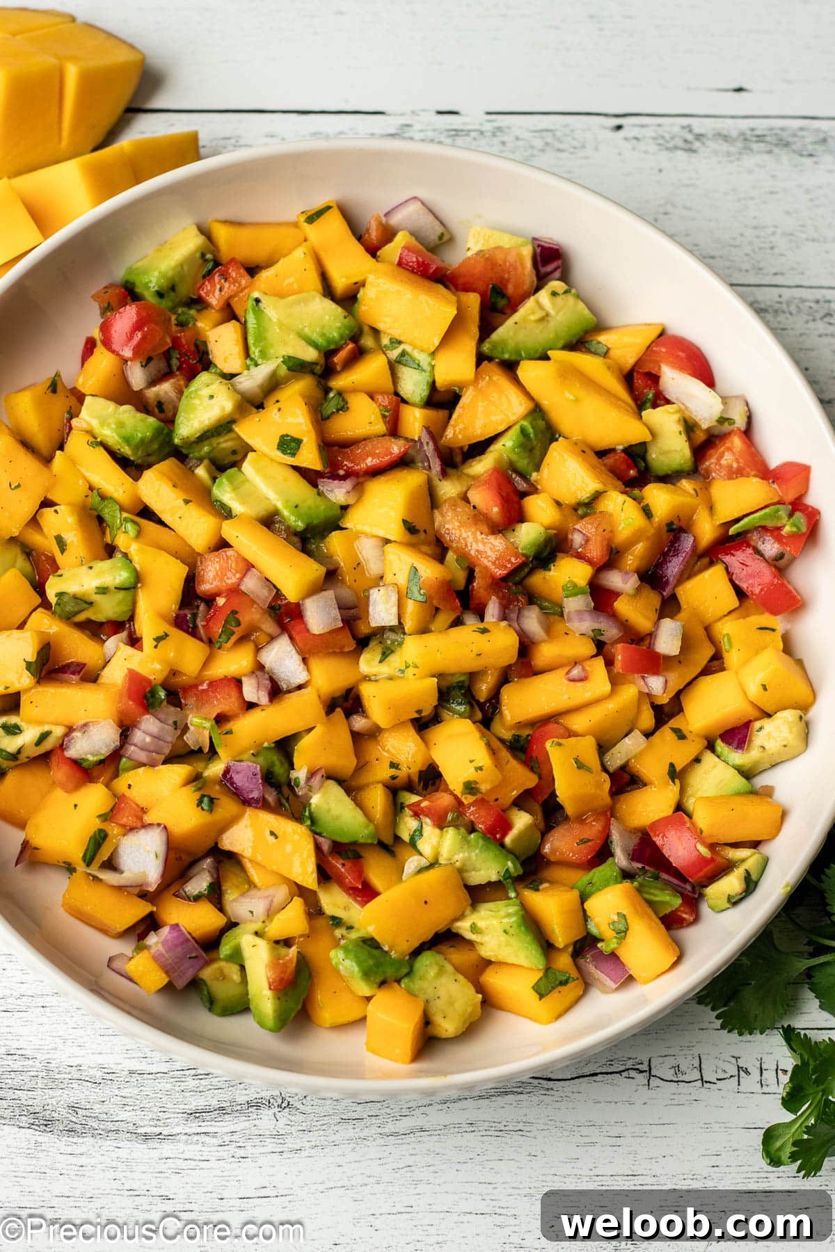 A bowl with diced mango, avocado, and other ingredients.