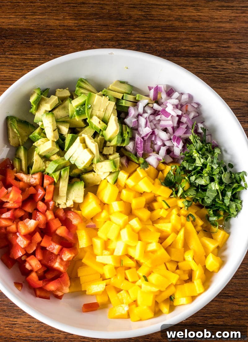 Chopped ingrediients for Mango Avocado Salsa in a bowl.