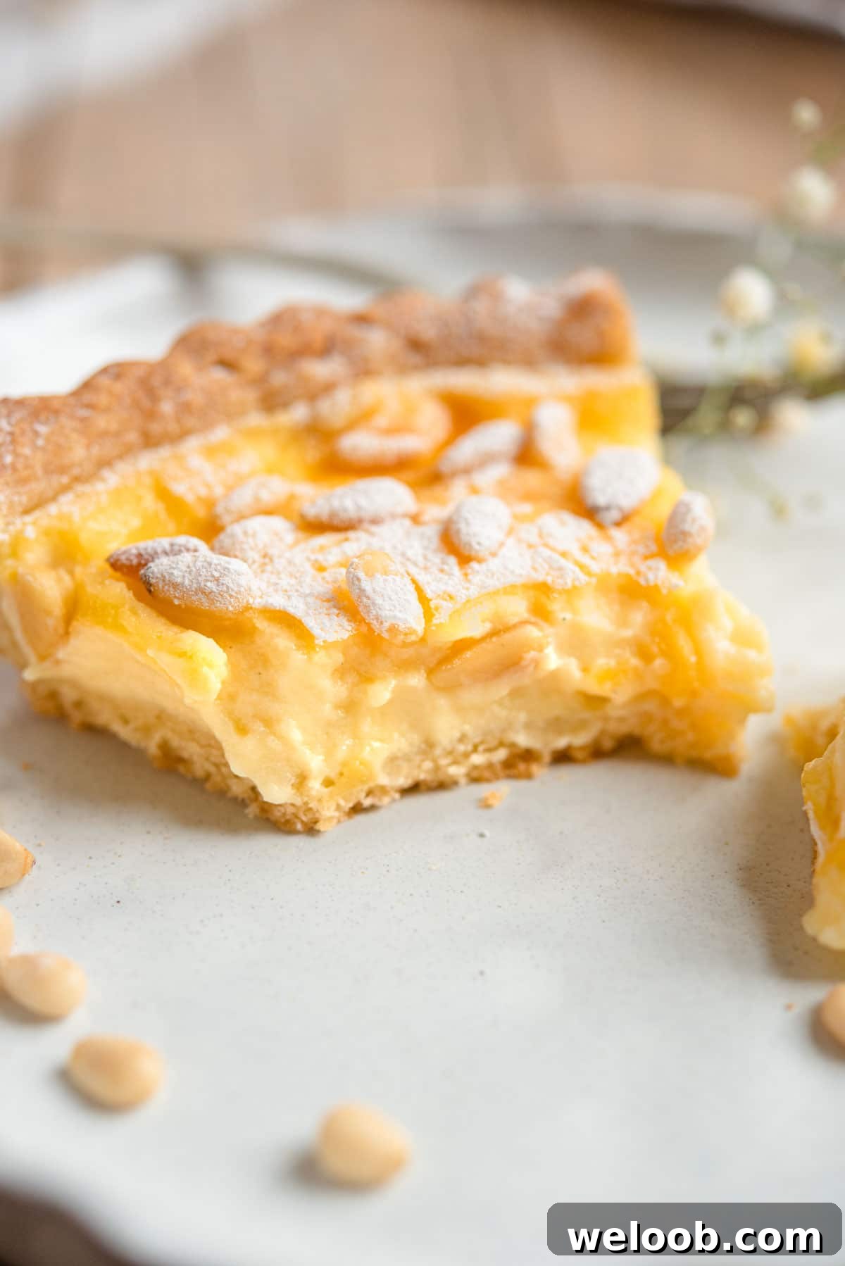 A close up of a slice of torta della nonna with a bite out