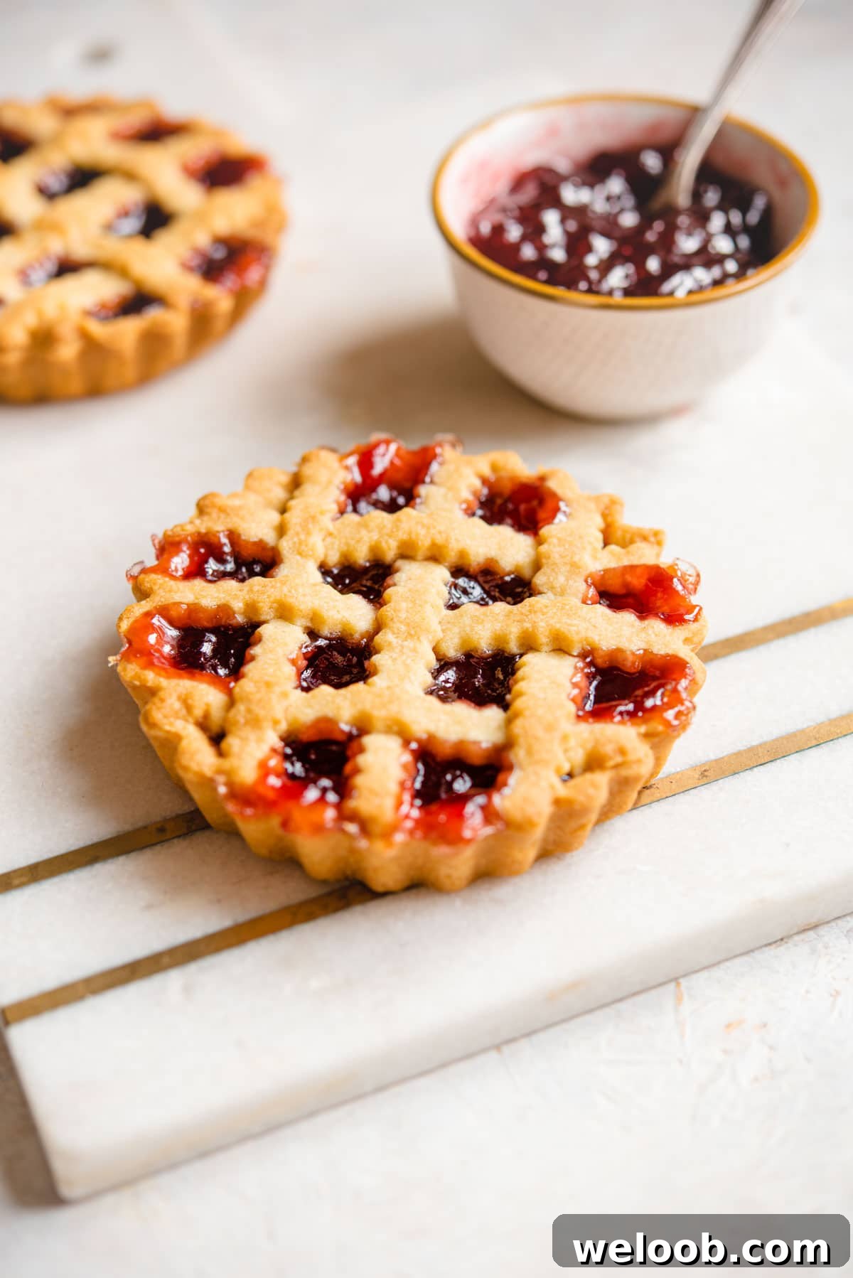 A mini Italian jam tart on a marble cutting board