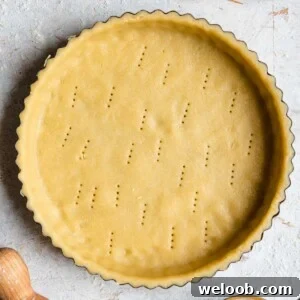 A square photo of raw sweet shortcrust pastry in a tart case
