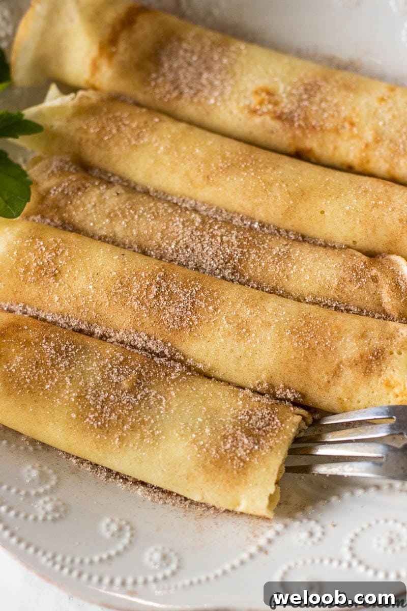 Perfect French Crepes: Thin, Tender, and Ready in Minutes 3 Crepes on a plate sprinkled with cinnamon sugar