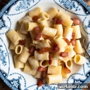 A cropped close up of Pasta alla Gricia in a blue and white bowl.