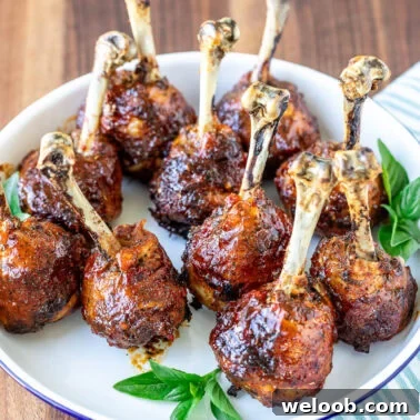 Plated sweet chili baked chicken drumstick lollipops.