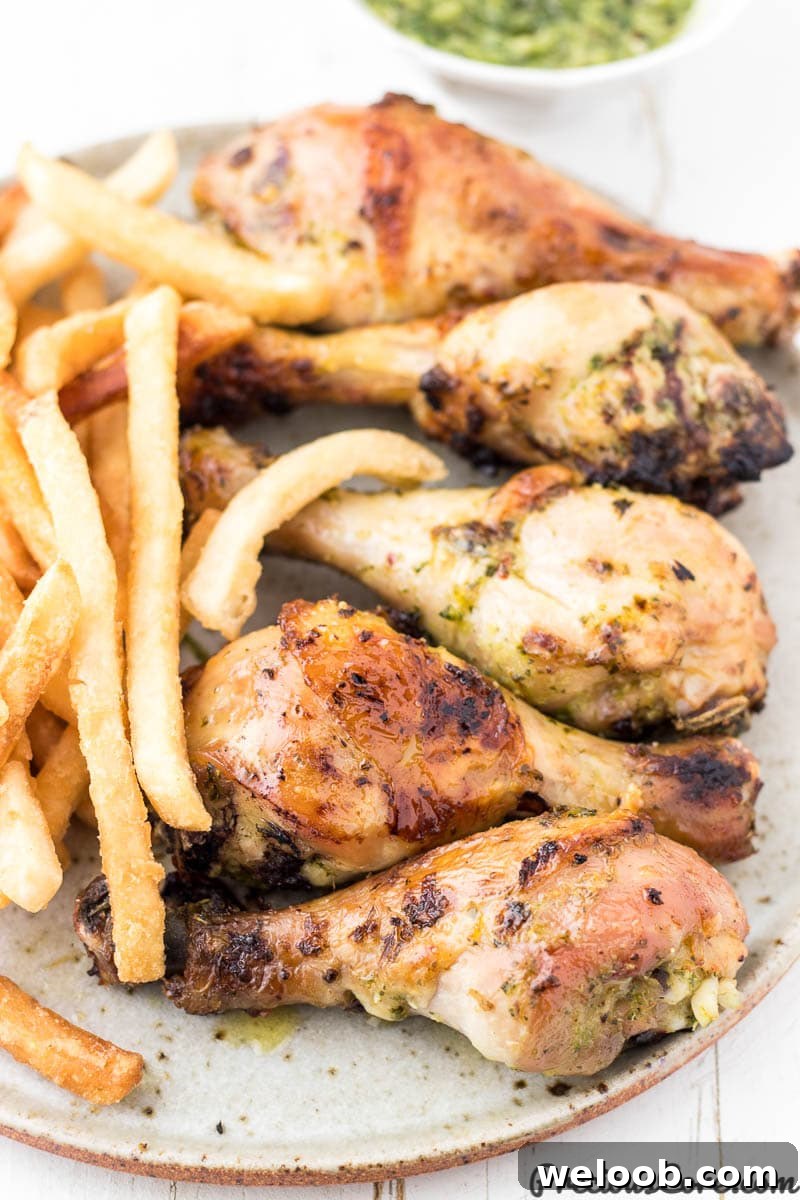 Chicken and fries on a plate with green sauce on the side