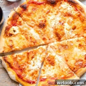A square image of a four cheese pizza cut into slices