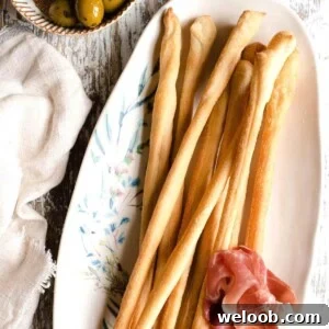 A square image of Italian breadsticks on a plate