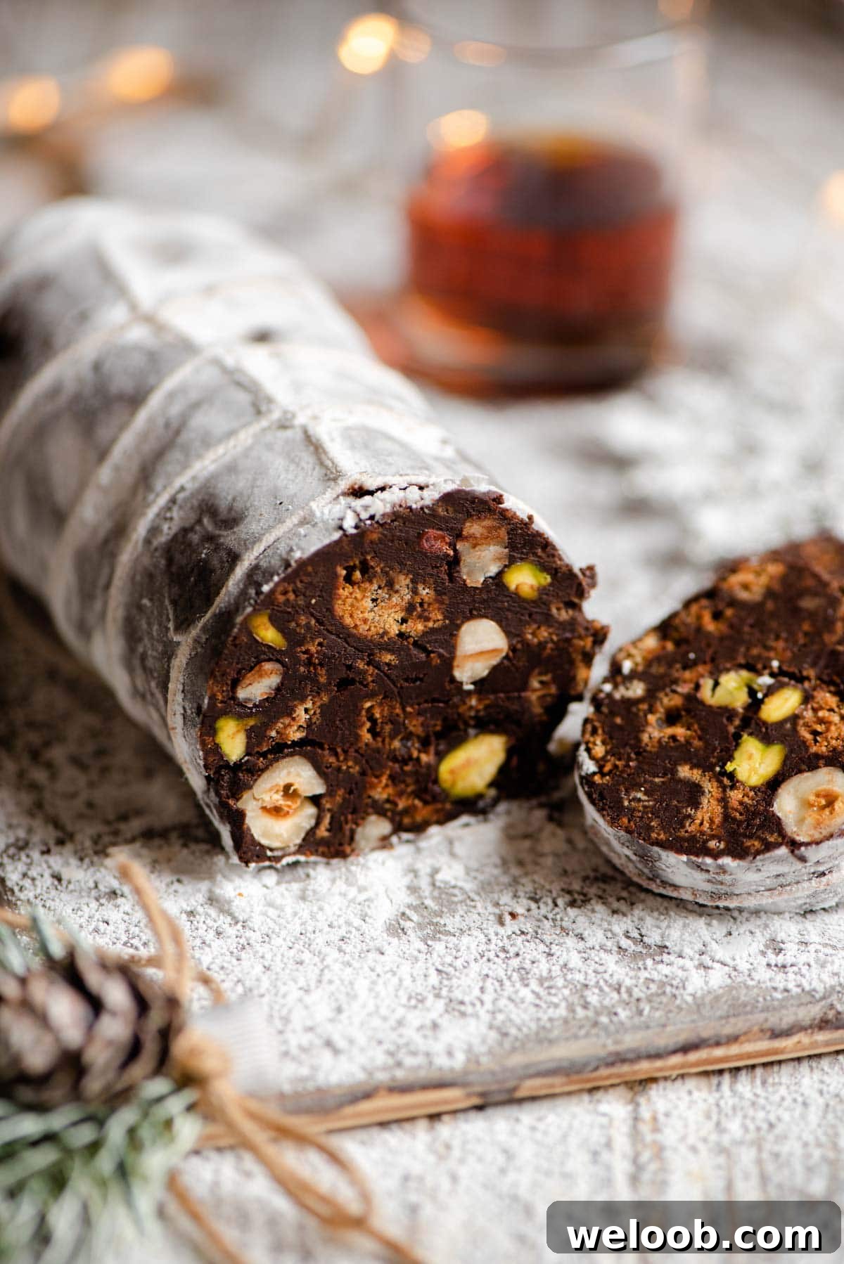 A close up of chocolate salami cut open showing the nuts and cookies inside