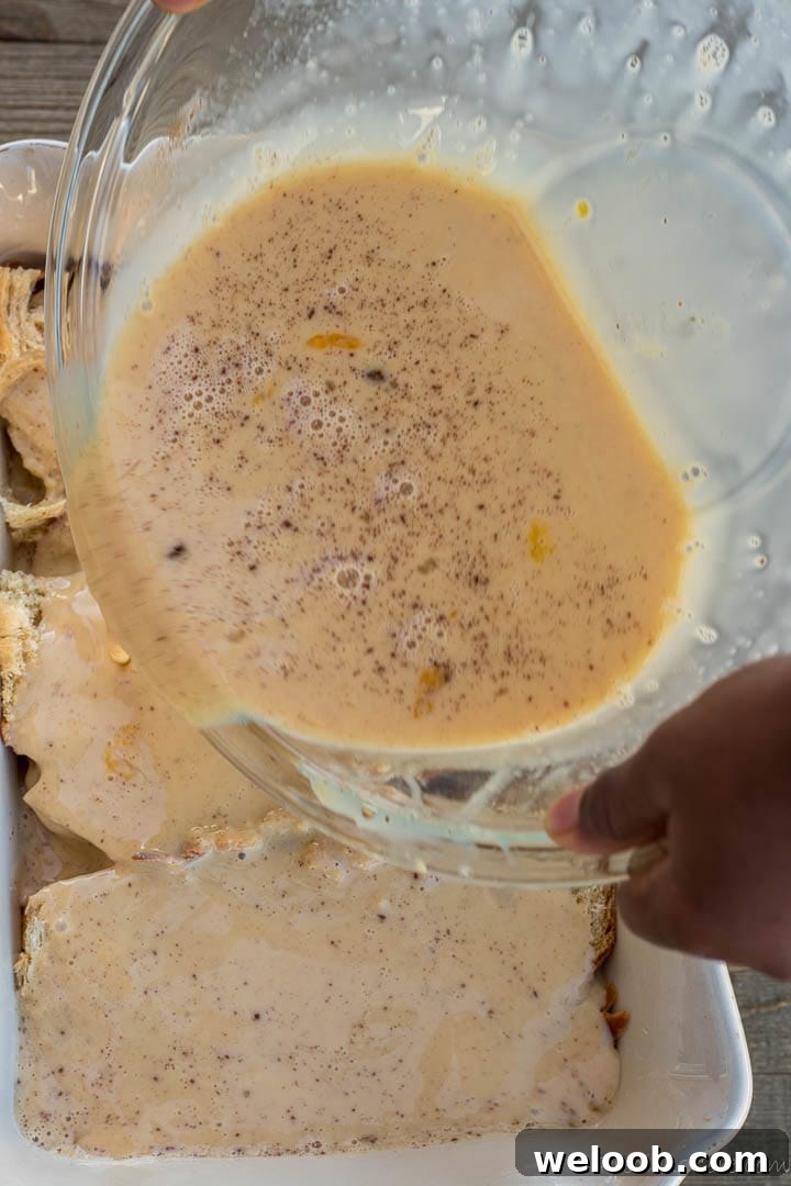 Pouring egg mixture over bread for bread pudding