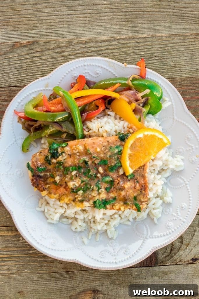 Plate of sauteed peppers, rice and baked salmon
