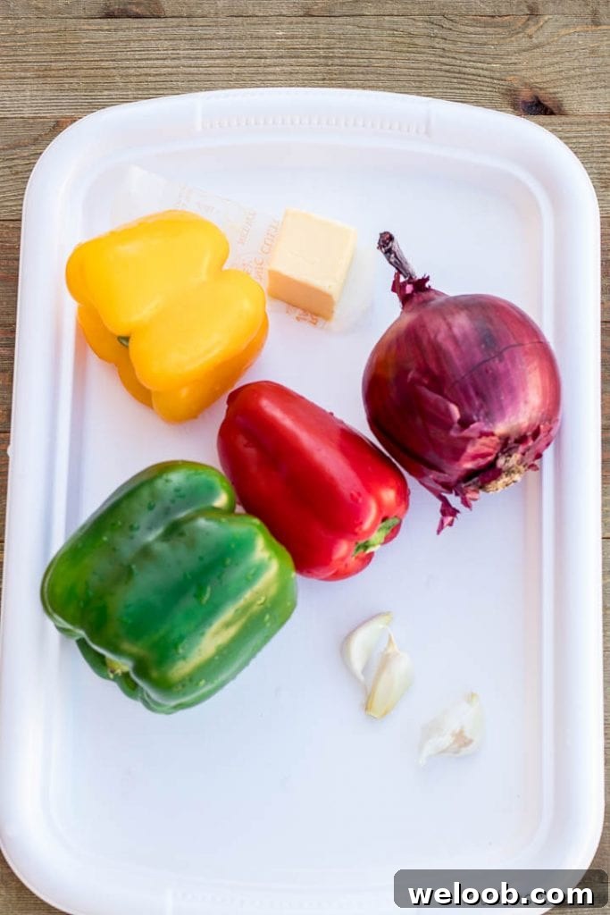 Colorful bell peppers on a tray with onions and garlic