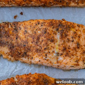 Baked Cajun salmon on parchment paper.