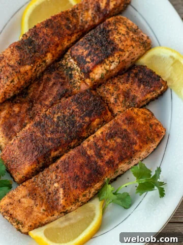 Four grilled salmon fillets on a serving platter