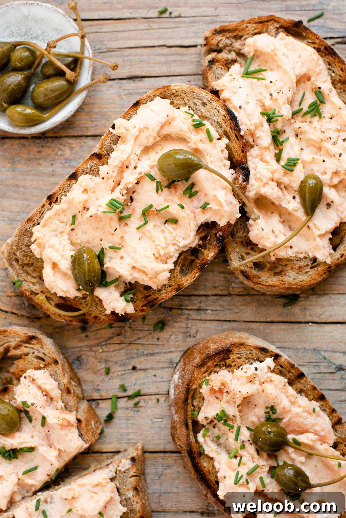 An overhead shot of smoked salmon crostini on a wooden surface