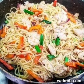 Stir fry with spaghetti and chicken in a pan
