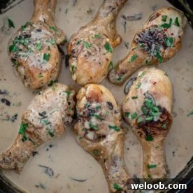 Chicken drumsticks in creamy sauce in a cast iron skillet
