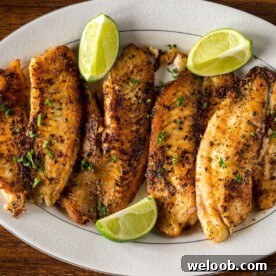 Pan Seared Tilapia on a serving tray with lime wedges
