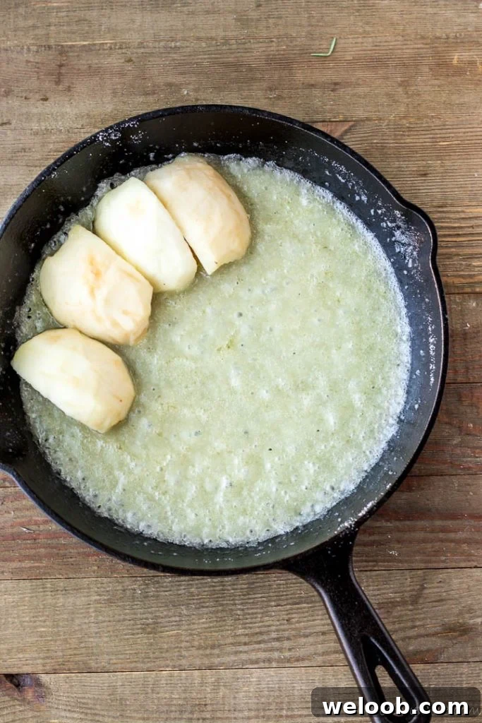 Apple slices over melted butter and sugar