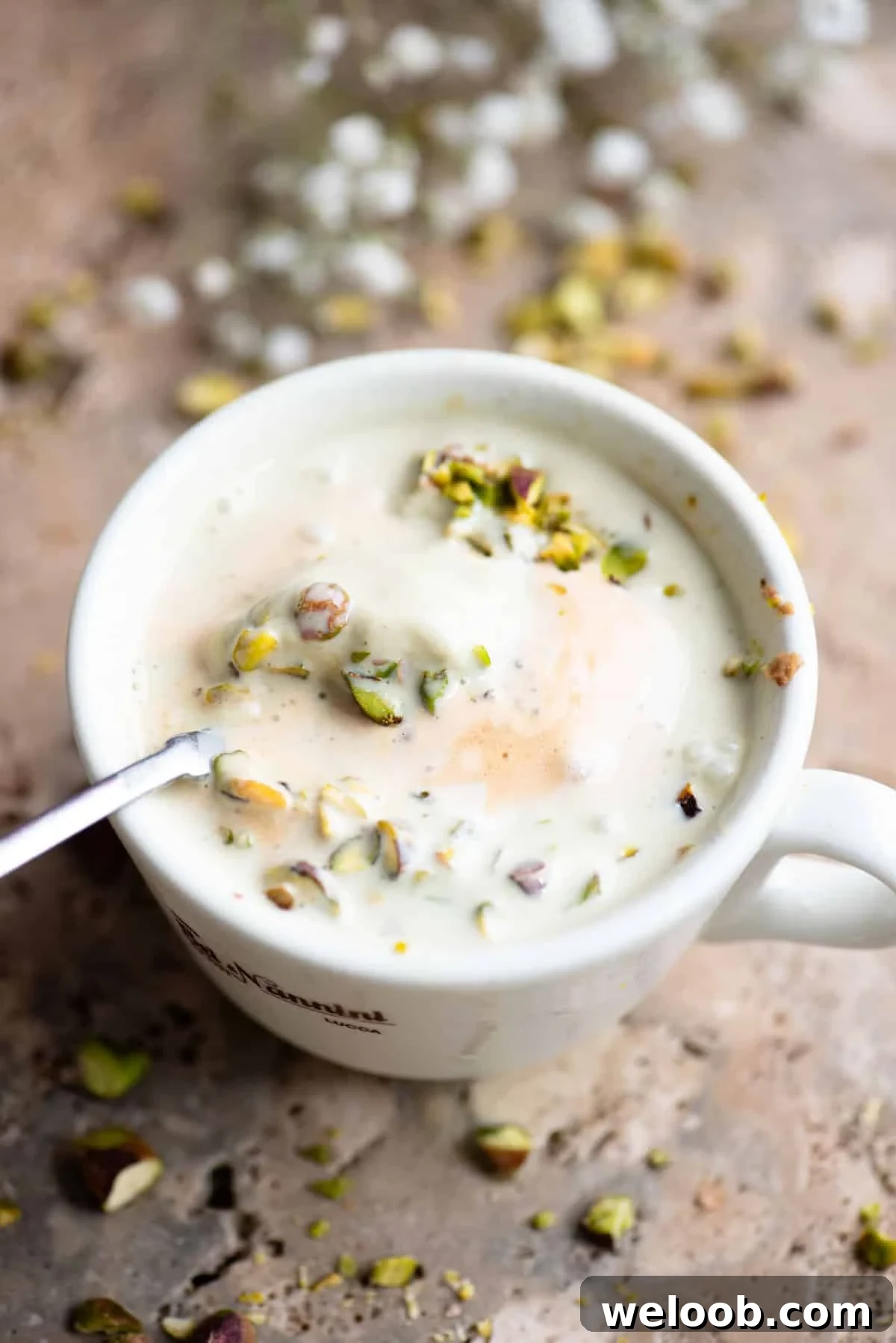 Pistachio Affogato Recipe: Creamy Pistachio Gelato with Espresso 4 A pistachio affogato mixed in a mug with a spoon inside.