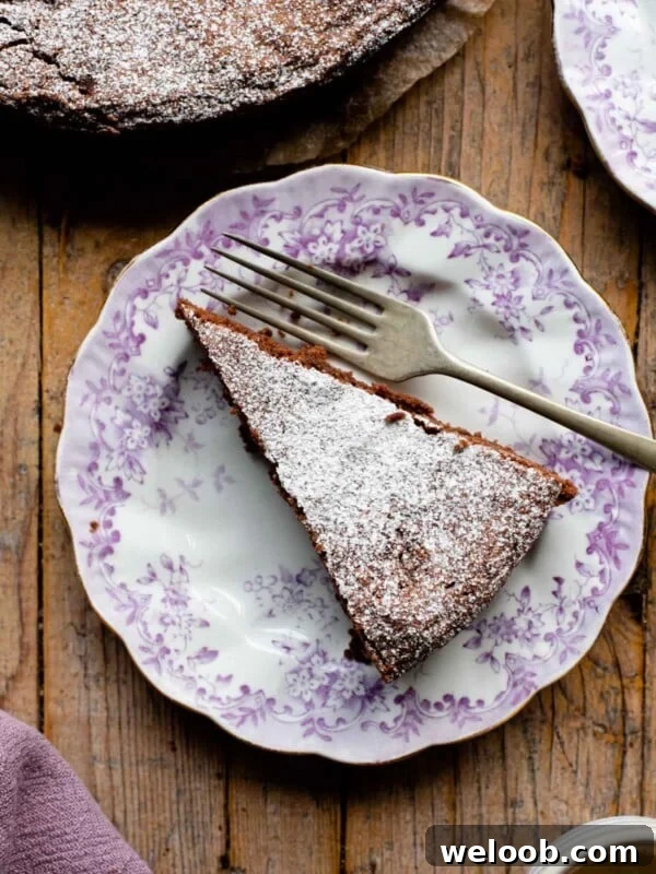 An overhead shot of a slice of chocolate torta caprese on a pink patterned plate