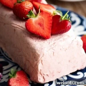 Silky Strawberry Semifreddo with Fresh Strawberry Sauce 9 A close up of strawberry semifreddo topped with fresh cut strawberries.
