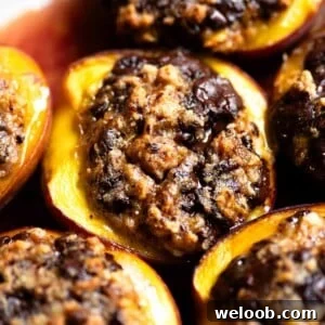 A close up of a baked peach stuffed with amaretti cookies and chocolate.