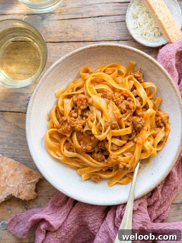 An overhead shot of tagliatelle bolognese in a rustic bowl