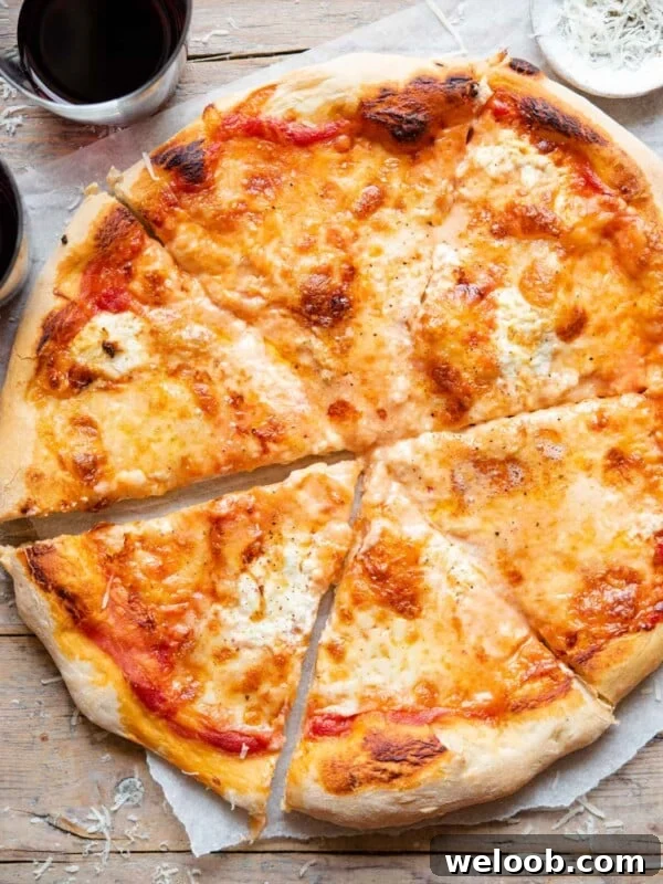 Mediterranean Olive, Anchovy and Caper Pizza with Oregano 5 An overhead shot of a four cheese pizza cut into slices
