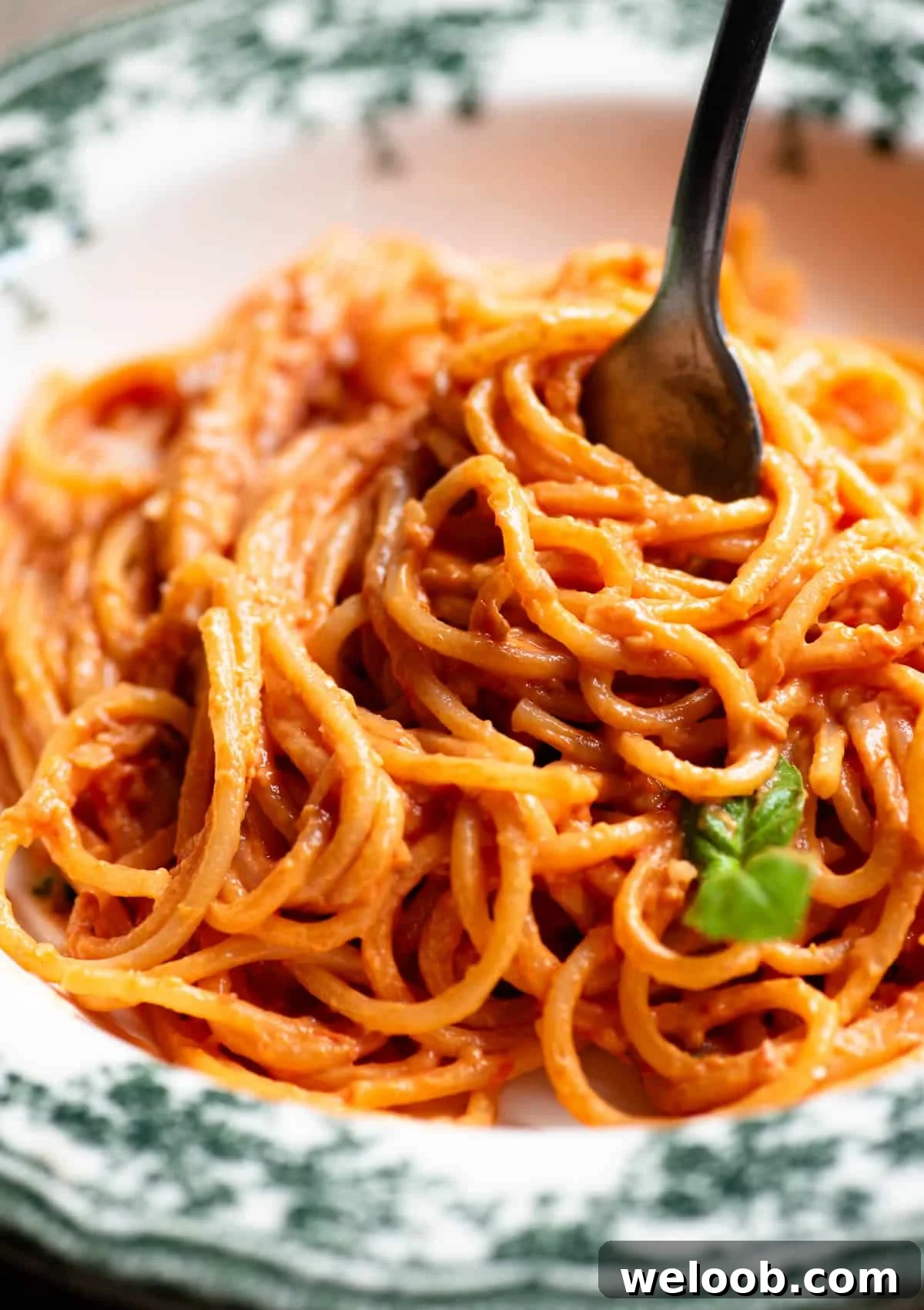 Creamy Ricotta Pasta with Roasted Cherry Tomatoes 4 A close up of tomato and ricotta spaghetti in a bowl and twisted round a fork.